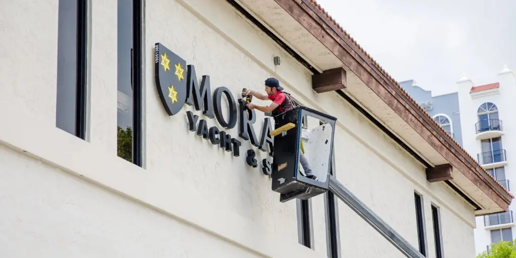 Montaż liter i logotypu na elewacji budynku z kosza zwyżki