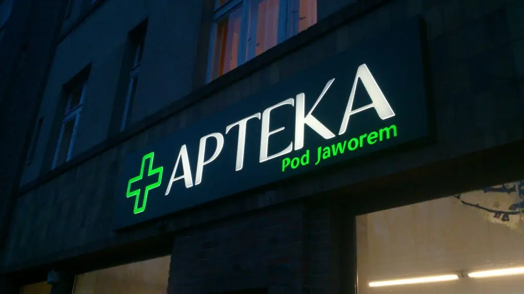 Podświetlany kaseton frezowany ze świecącym napisem i znakiem na ciemnym licu