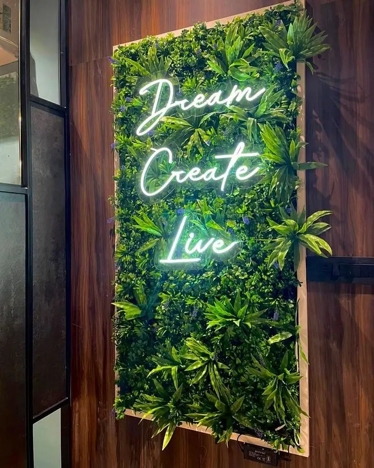 Neon LED z napisem na ścianie z zieleni